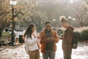 teens on phones smiling - mobile banking
