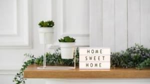 Plants on a table with a little light up sign that says Home Sweet Home