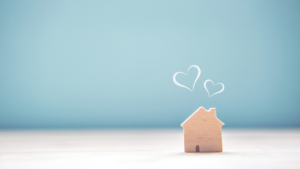 Little wooden house with white hearts about it on a blue background