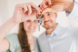 Two people holding up keys to new home