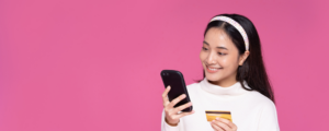 Woman smiling at phone with card in hand