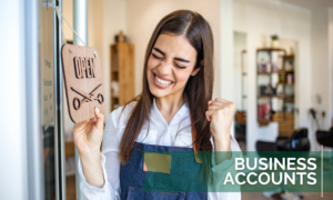Woman celebrating with open sign on business door - Business Accounts Slider