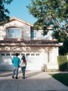 home owners thinking about Home Maintenance Checklist in driveway